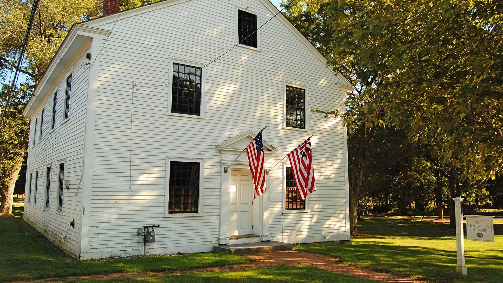 Lynnfield Old Meeting House, a white clapboard colonial meetinghouse with American flags, Lynnfield, Massachusetts